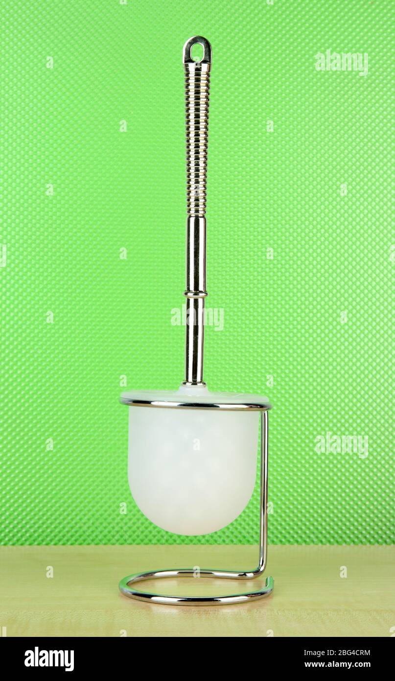 Toilet brush on green background Stock Photo - Alamy