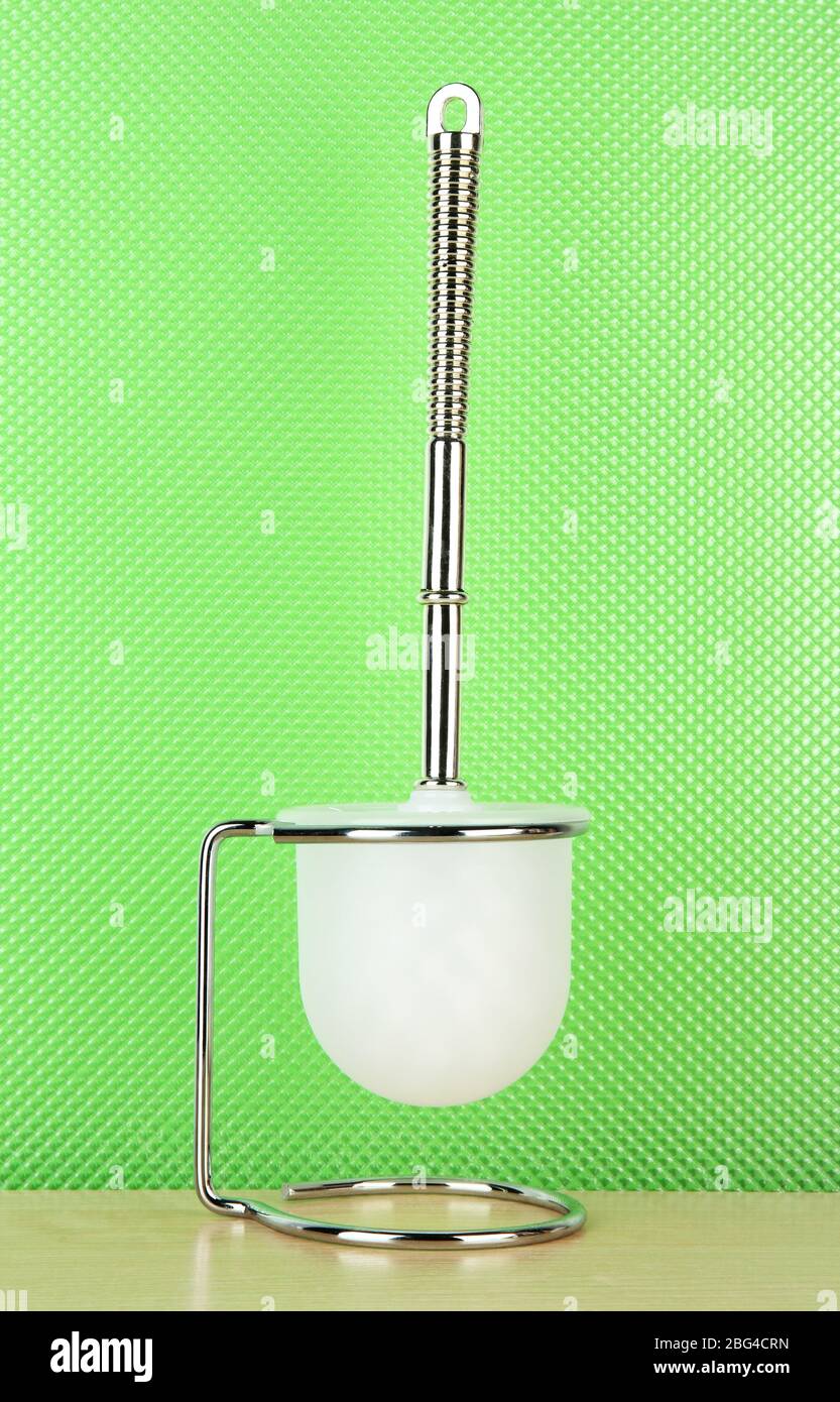 Toilet brush on green background Stock Photo - Alamy