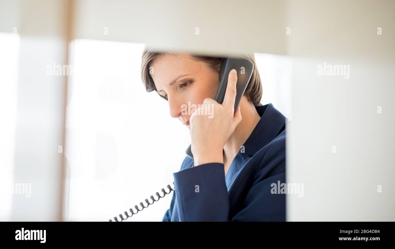 Pretty Young Businesswoman with Short Hair Talking to Someone Using
