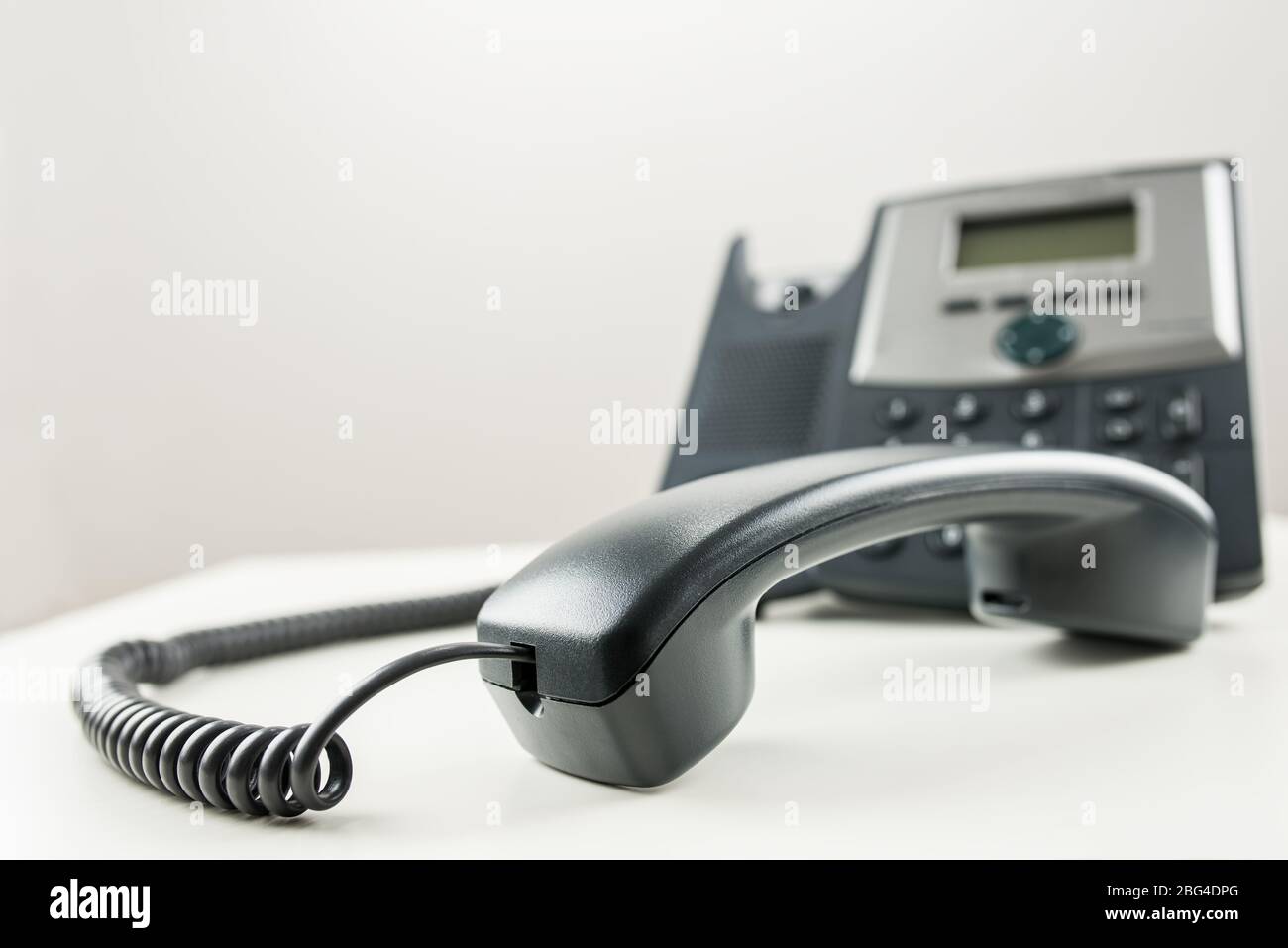 Classic black landline telephone with handset off the hook Stock Photo