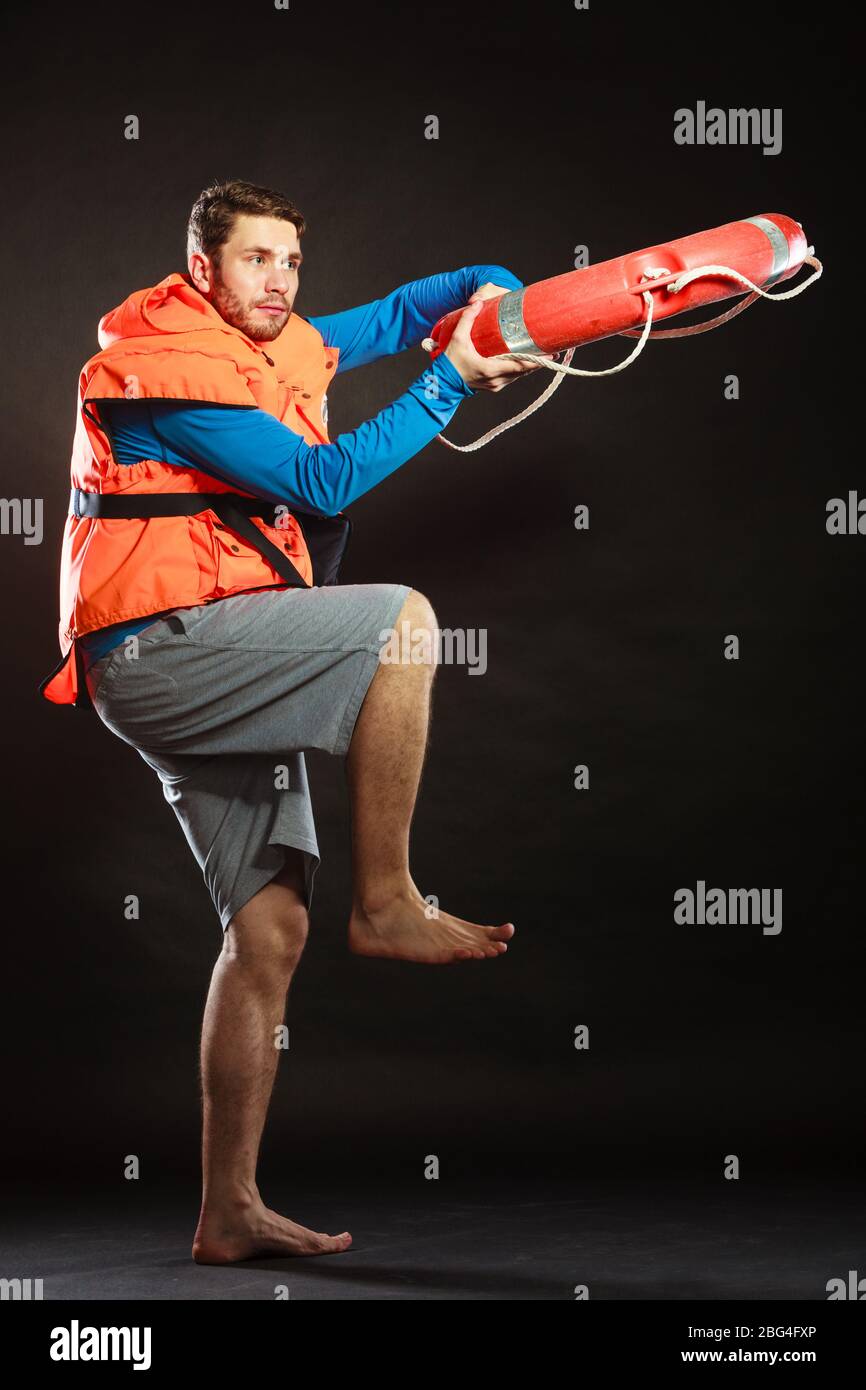 Lifeguard in life vest jacket throwing ring buoy lifebuoy. Man