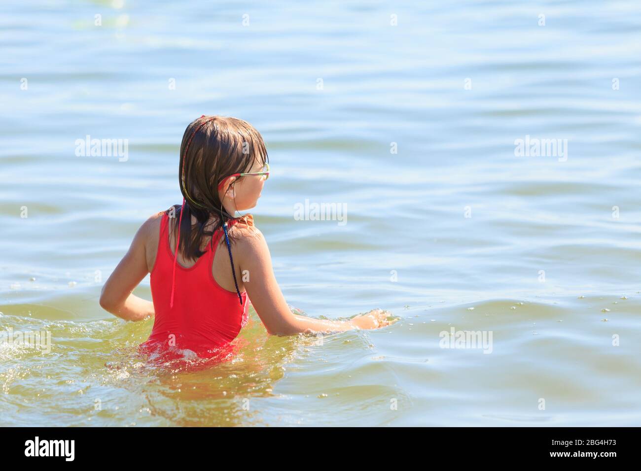 Little girl child having fun in ocean. Kid and woman bathing in sea
