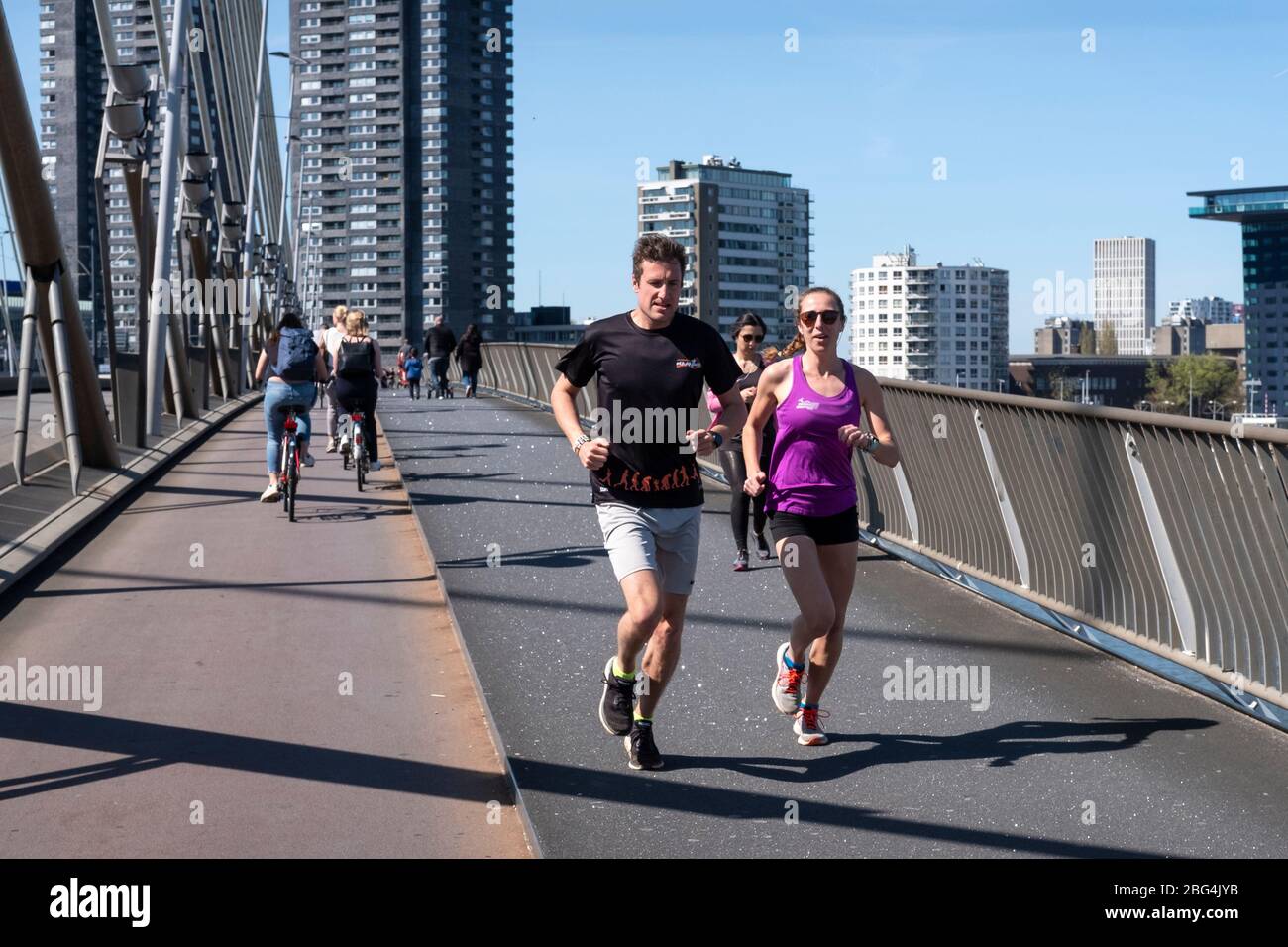 Joggers on the Erasmus Bridge in Rotterdam, Netherlands. The famous marathon of Rotterdam was canceled due to the corona crisis. Stock Photo