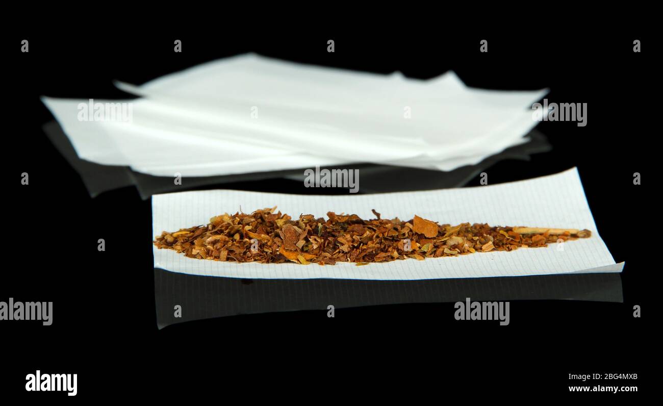 Tobacco and rolling papers, isolated on black Stock Photo Alamy