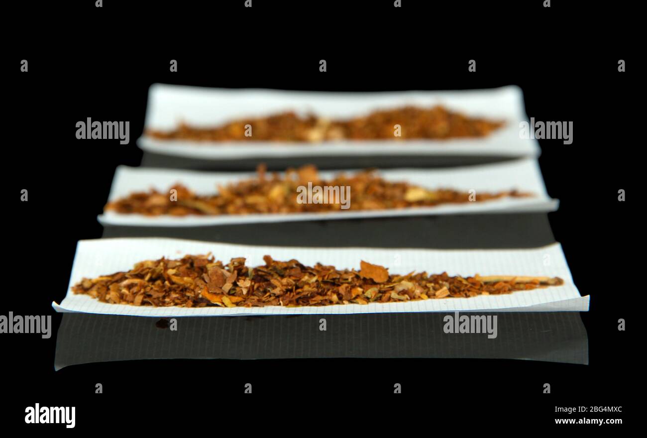 Tobacco and rolling papers, isolated on black Stock Photo Alamy