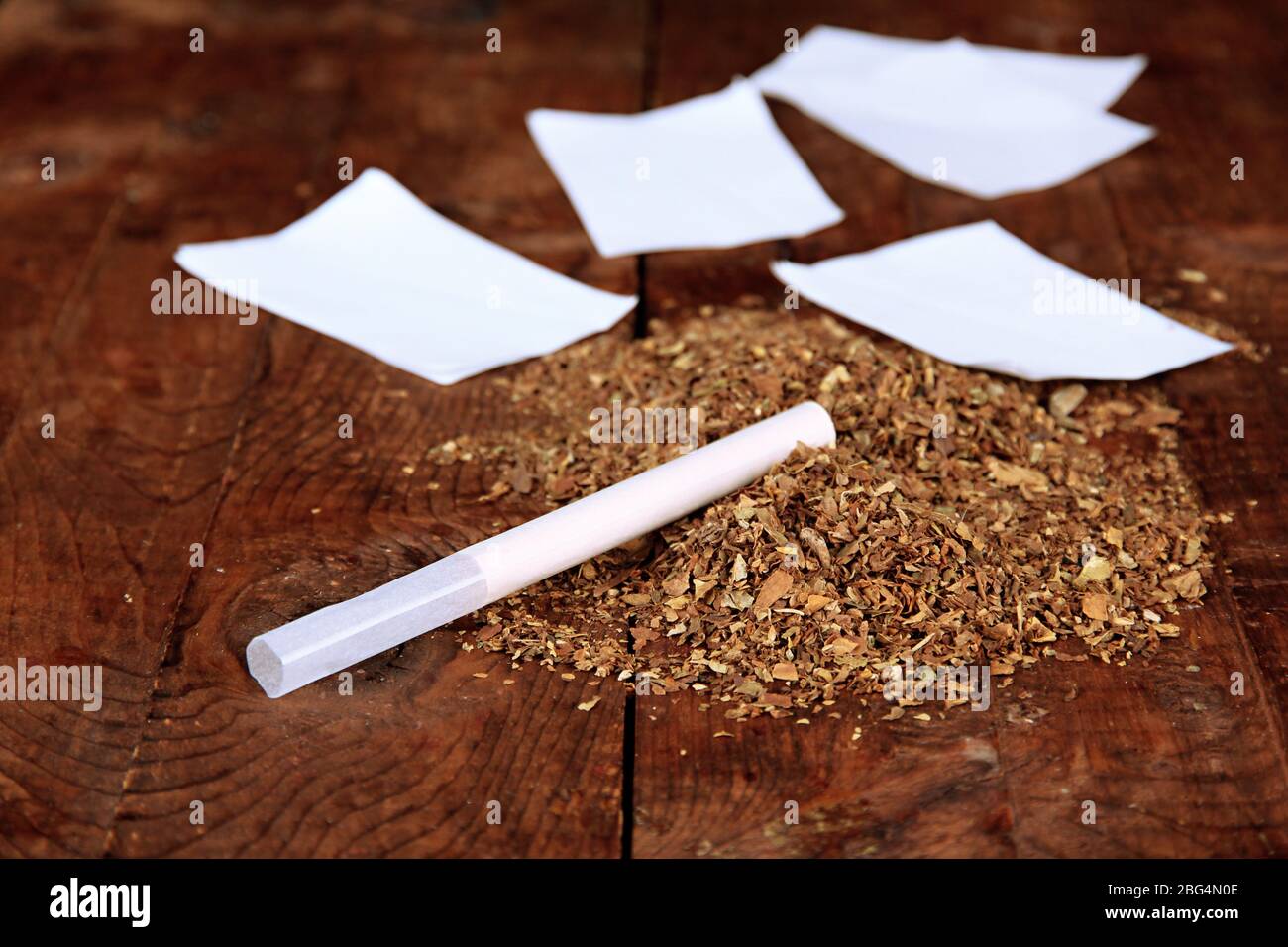 tobacco background Tobacco and rolling paper, on wooden background Stock Photo
