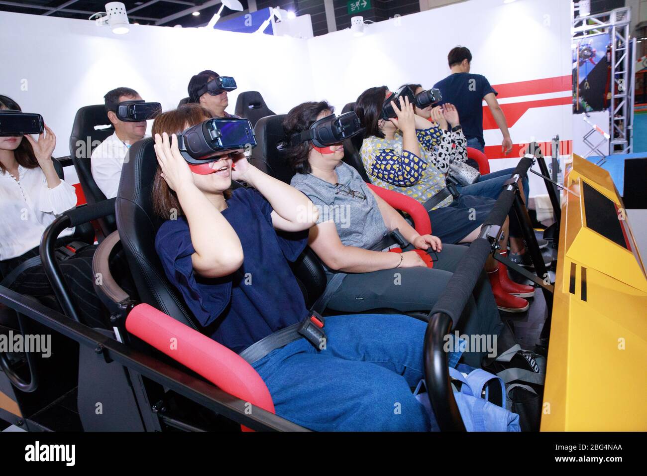 A small group of people experience a virtual reality amusement ride Stock Photo