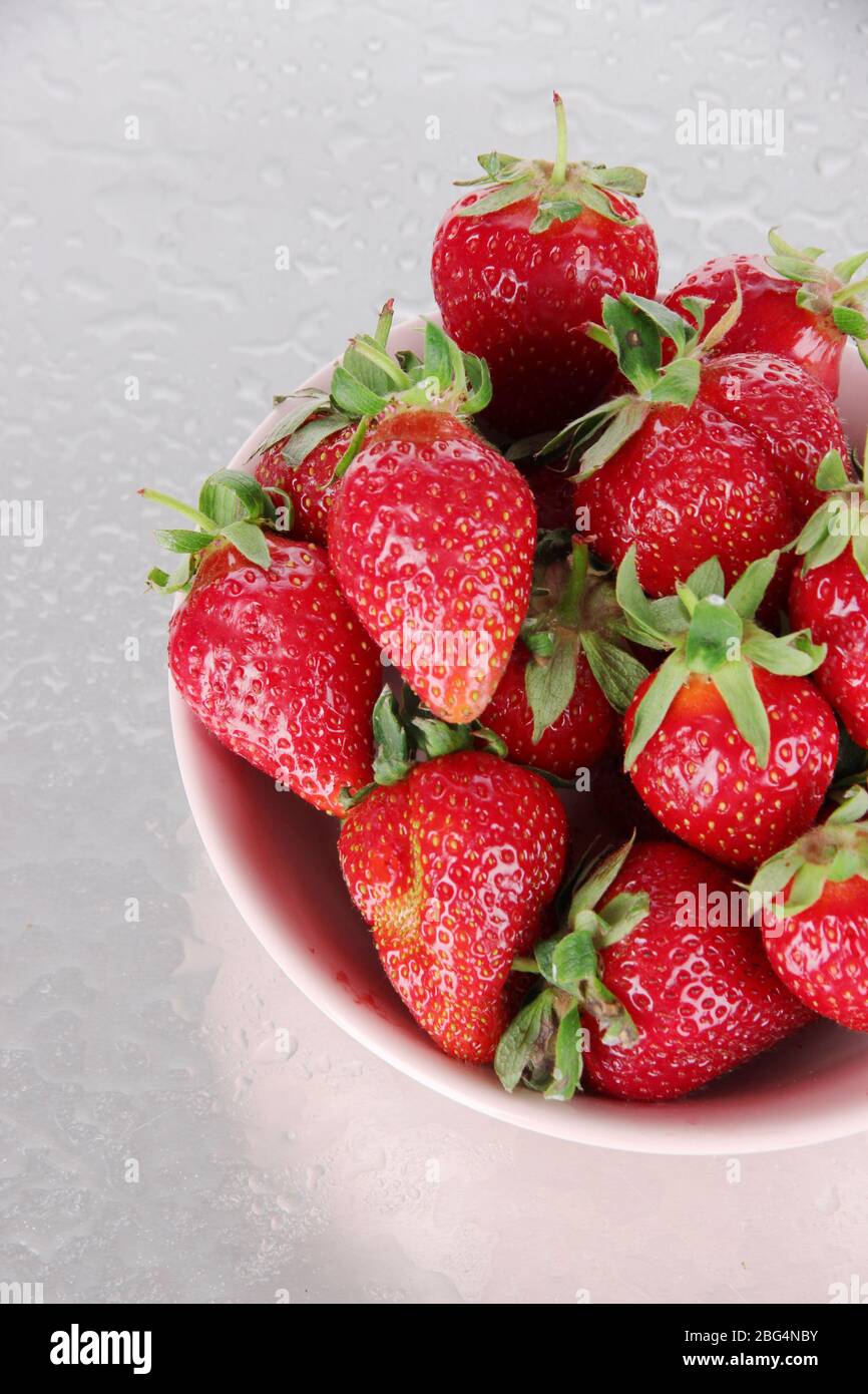 Strawberries in bowl on metal background Stock Photo - Alamy