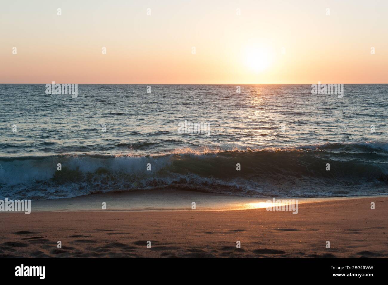 Sun setting over Pacific Ocean at beach in Mexico Stock Photo