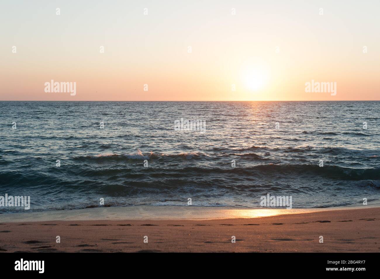 Sun setting over Pacific Ocean at beach in Mexico Stock Photo