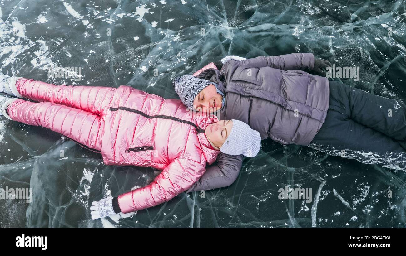 Couple has fun during winter walk against background of ice of f Stock Photo