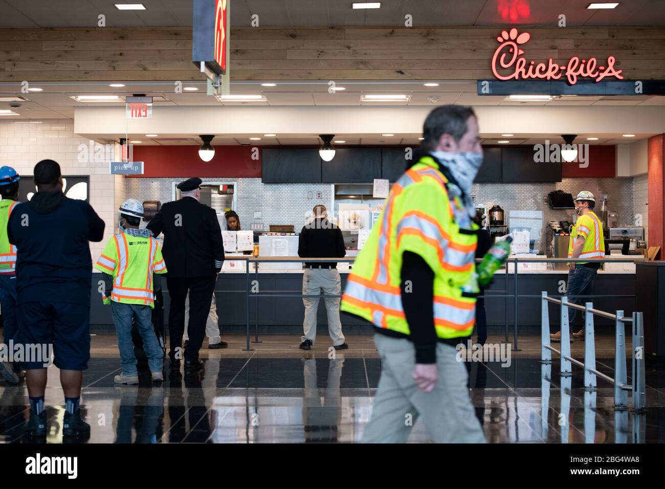 Washington, USA. 20th Apr, 2020. Construction workers and travelers wait for food at a Chic-Fil-A location at Ronald Reagan Washington National Airport near Washington, DC on April 20, 2020 amid the Coronavirus pandemic. Over the weekend, Congressional negotiations continued on an additional economic stimulus bill in response to the worsening COVID-19 outbreak, as President Trump encouraged protesters nationwide who demonstrated to reopen the economy and end social distancing measures. (Graeme Sloan/Sipa USA) Credit: Sipa USA/Alamy Live News Stock Photo