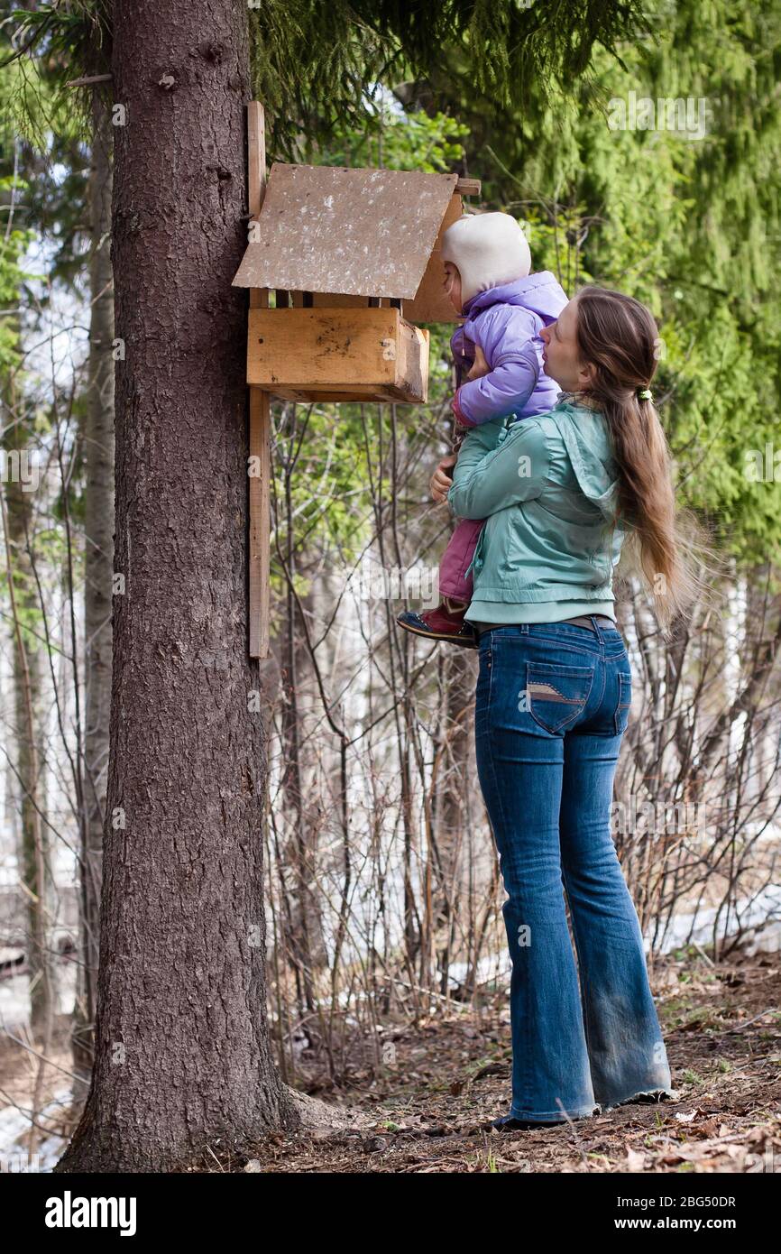 mother shows her daughter the bird feeder in the park Stock Photo