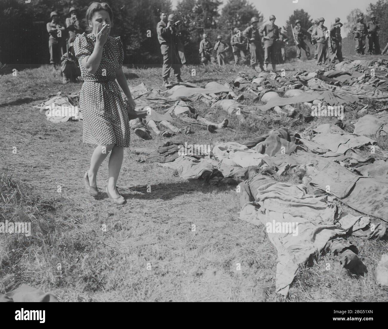 Second World War documentary. Second World War documentary. A young German woman reacts with horror as she walks by some of the approximately 800 prisoners murdered by SS guards near Namering, Germany, and laid there so that townspeople could view the work of their Nazi leaders, May 1945 Stock Photo