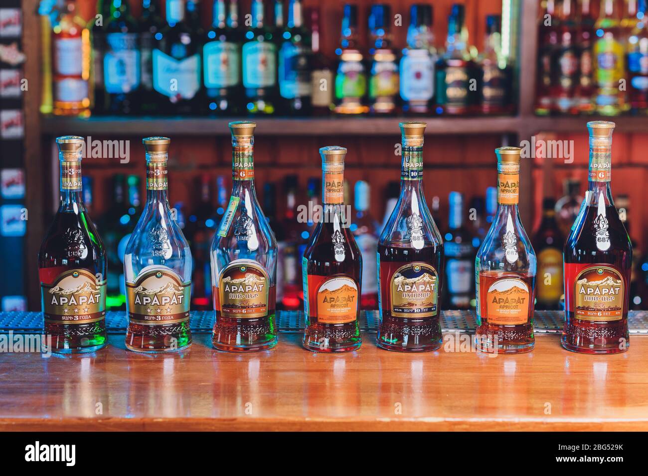 Ufa, Russia, 6 January, 2020: glasses filled with Armenian cognac Ararat on a tasting table close-up on background of bottles Stock Photo