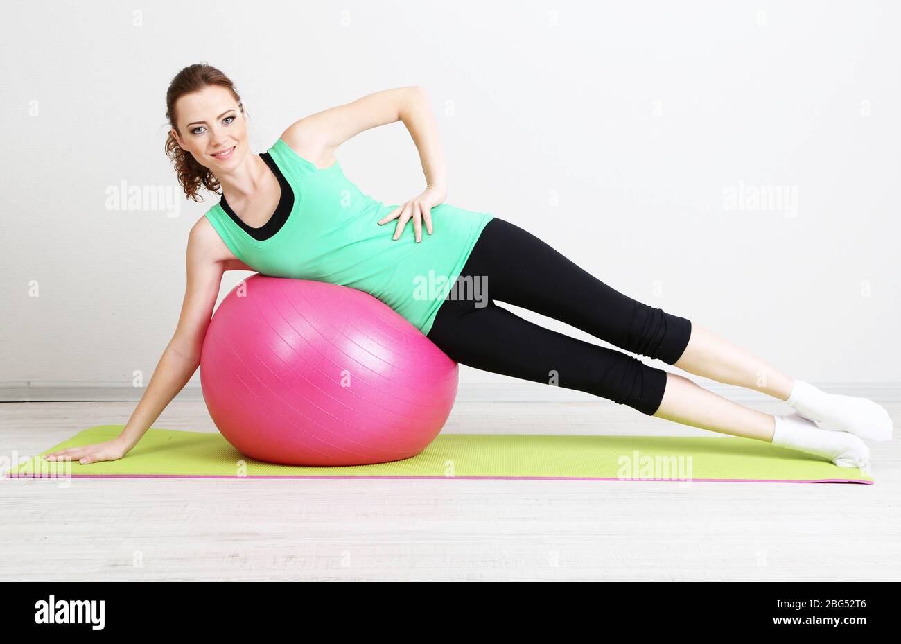 Portrait of beautiful young woman exercises with gym ball Stock Photo