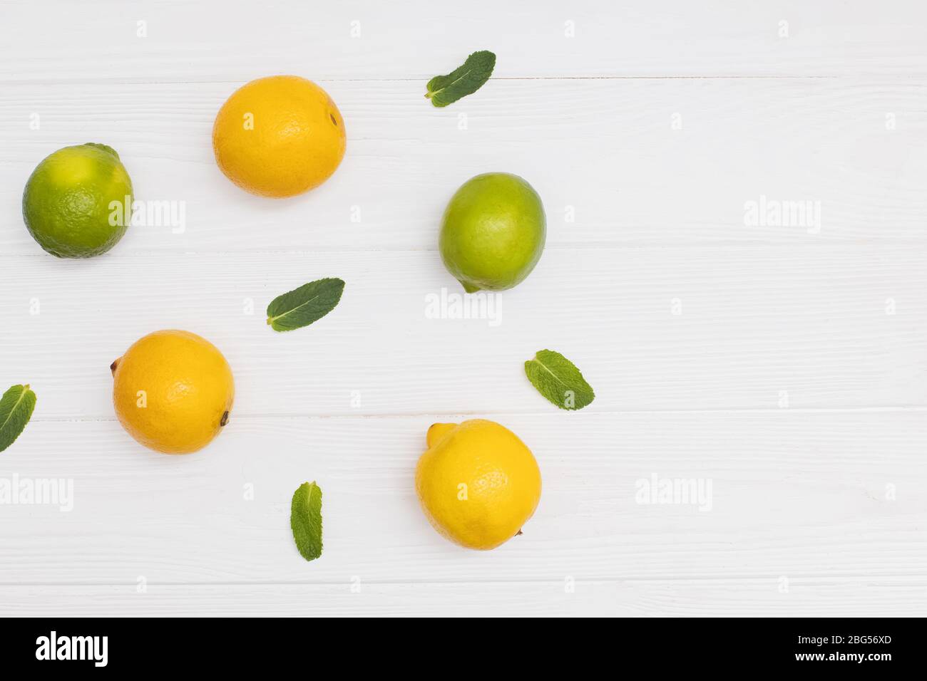 Creative composition with yellow lemons, green limes and mint sprigs Stock Photo