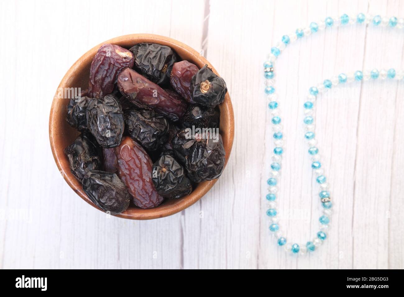 high angle view of date fruit in a bowl on white  Stock Photo