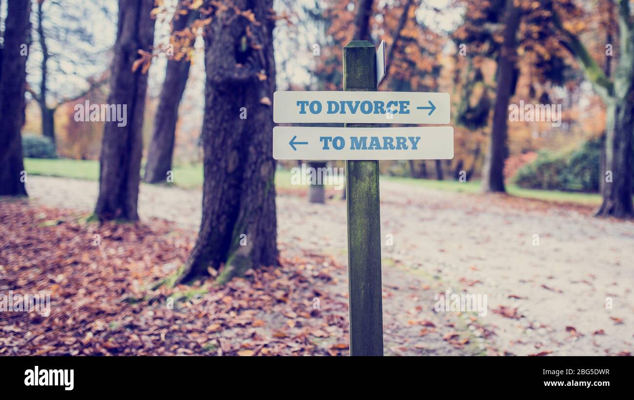 Vintage Wooden Signpost at the Park with Conceptual Directions for To Divorce and To Marry. Stock Photo