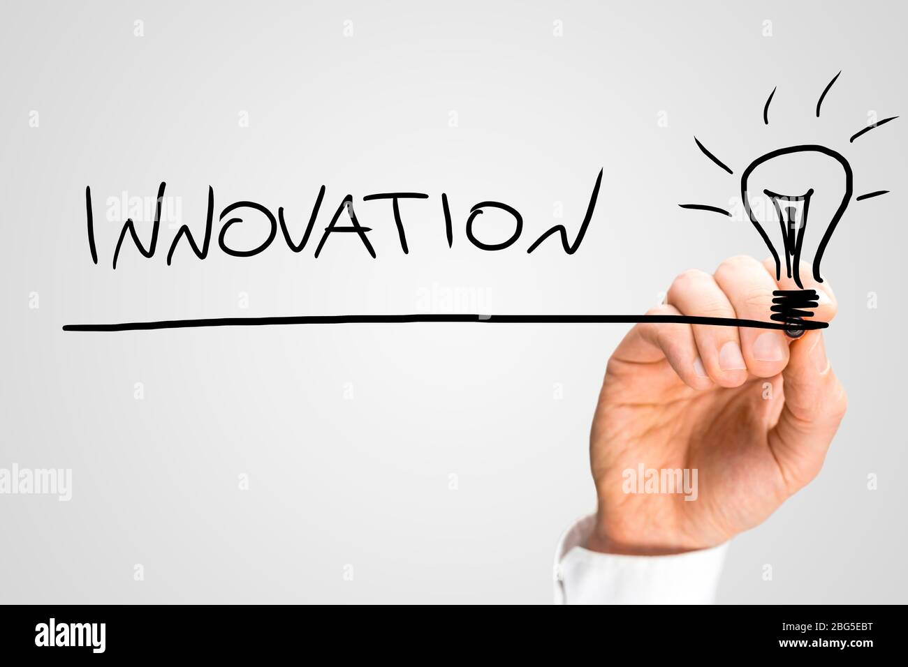 Male hand drawing light bulb and writing word Innovation on a virtual ...