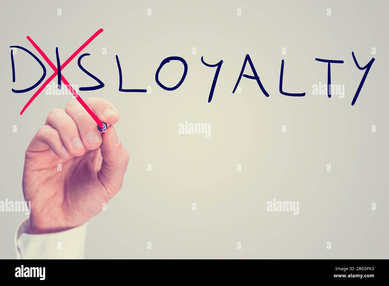 Conceptual image with word Disloyalty being changed into Loyalty. With retro filter or instagram effect. Stock Photo