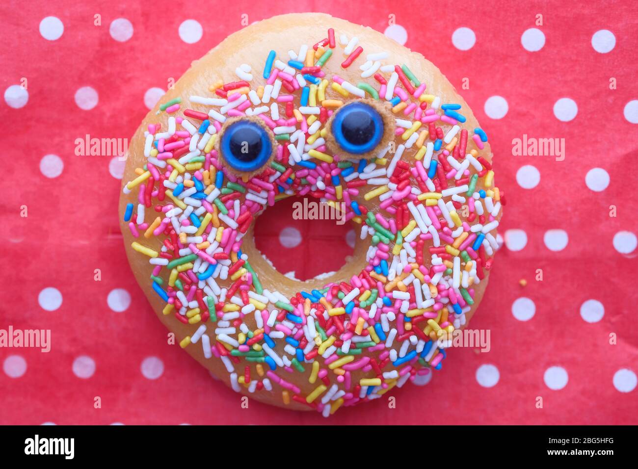 Funny smiling face donut with sprinkles on red background Stock Photo -  Alamy