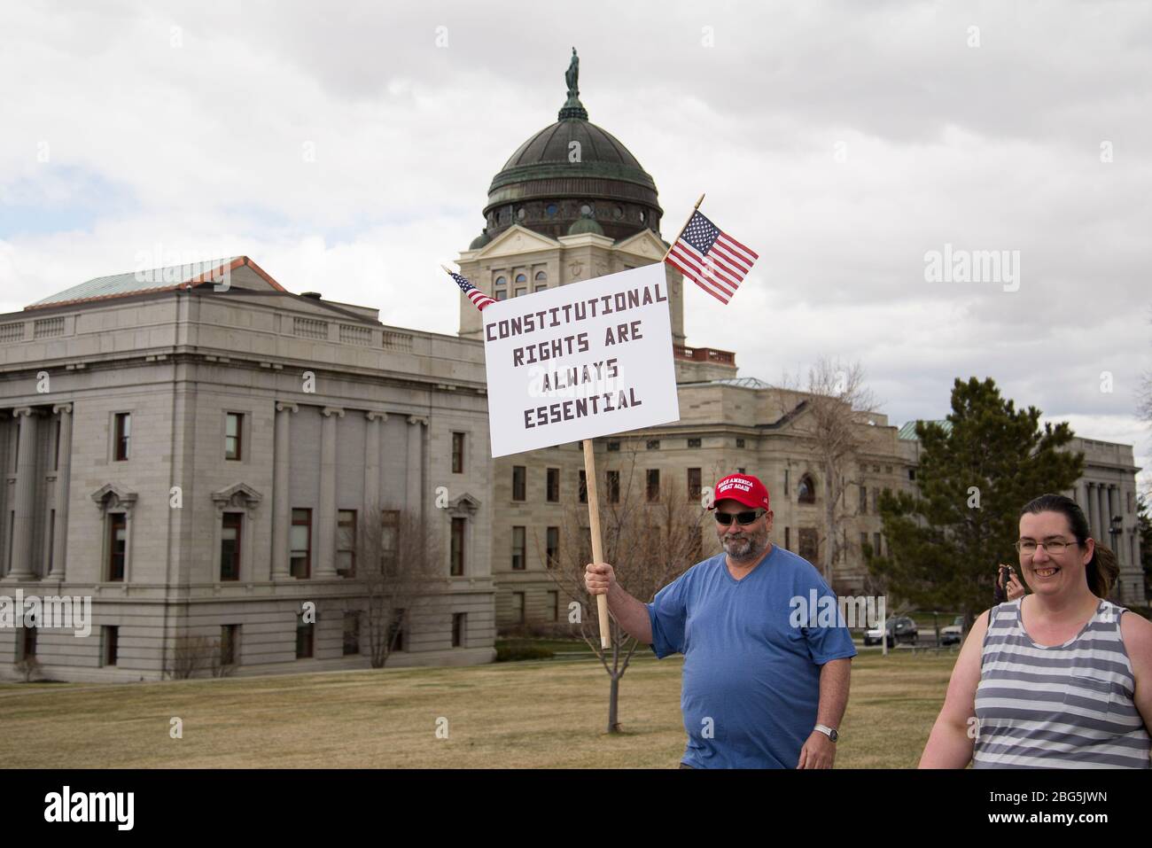 Helena, Montana - April 19, 2020: Man protesting wearing Make America Great Again hat holding constitutional rights are essential sign at a protest ag Stock Photo