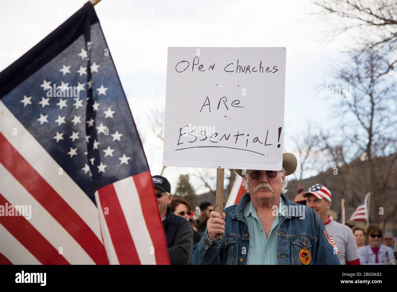 Helena, Montana - April 19, 2020: Marine Corps veteran protesting and holding sign that churches are essential again the government shutdown with an A Stock Photo