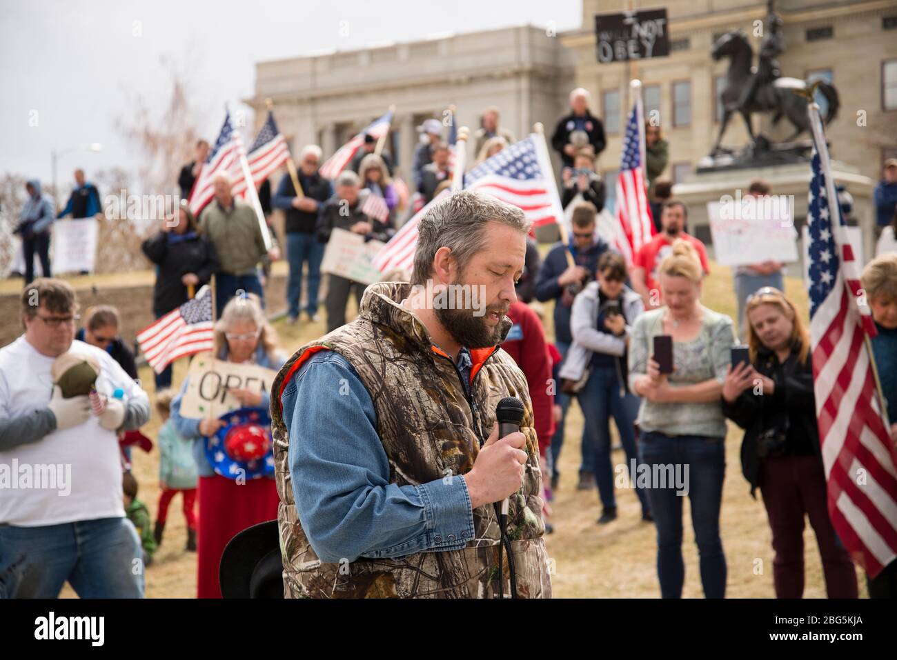 Helena, Montana - April 19, 2020: A man speaking and praying at a protest liberty rally at the Capitol again the shutdown due to Coronavirus. A crowd Stock Photo