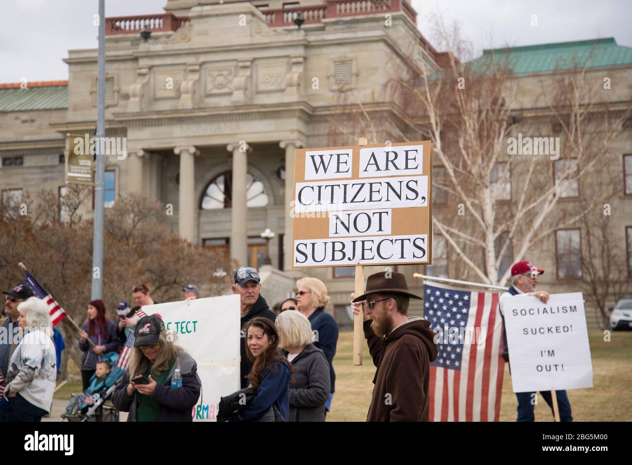 Helena, Montana - April 19, 2020: A protesting man holds a sign at a rally at the Capitol against the government shutdown. Wanting to reopen the econo Stock Photo