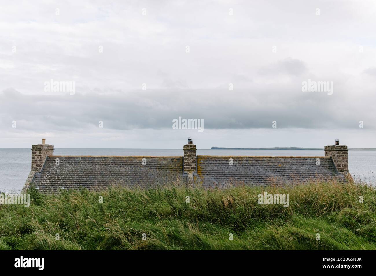 View out to sea over the rooftop of a house overlooking the historic harbour of the small