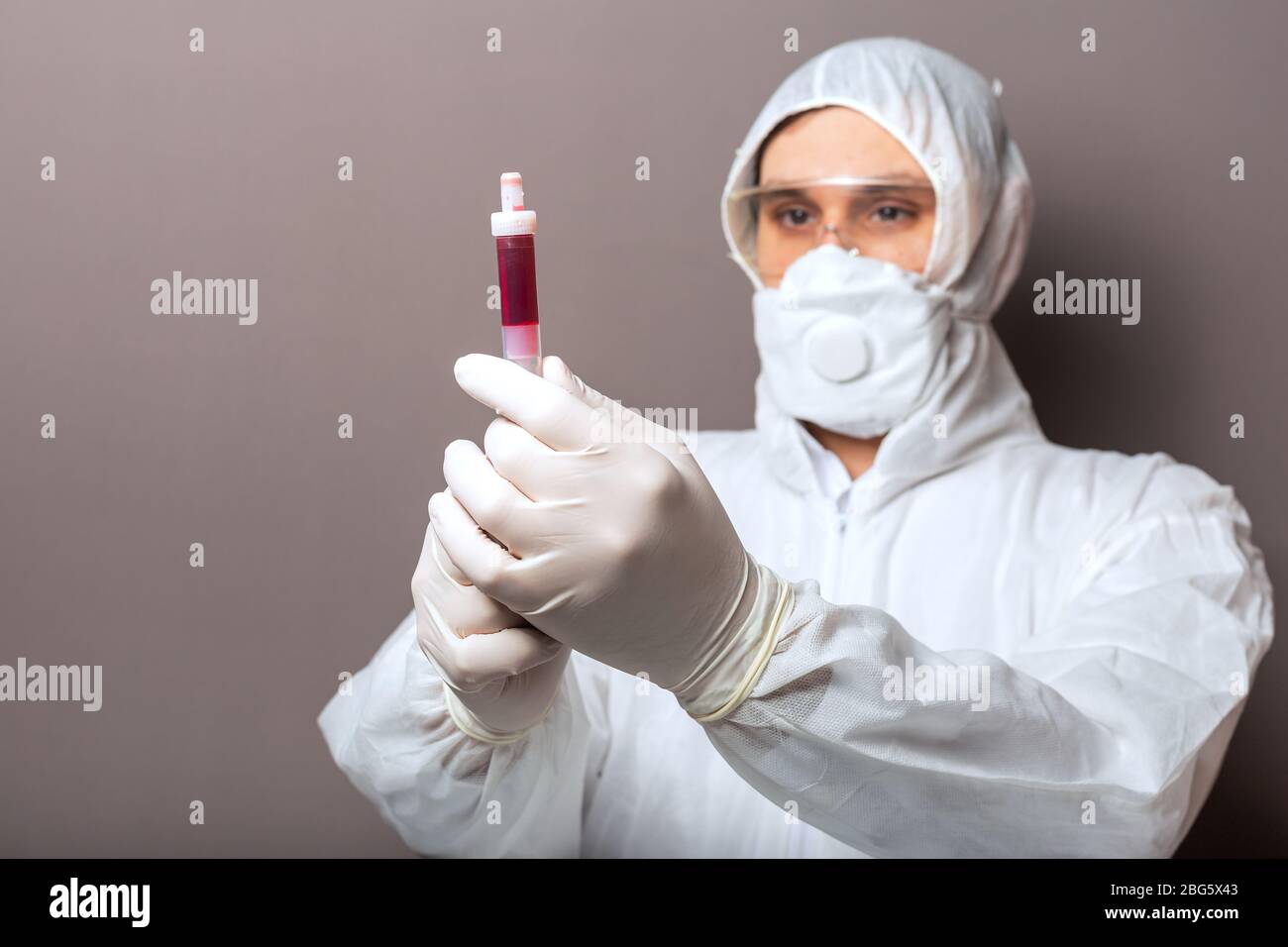 Coronavirus, covid-19 blood test in doctors hands. Doctor in protective medical suit, biological hazard, medical mask,protective gloves on white Stock Photo