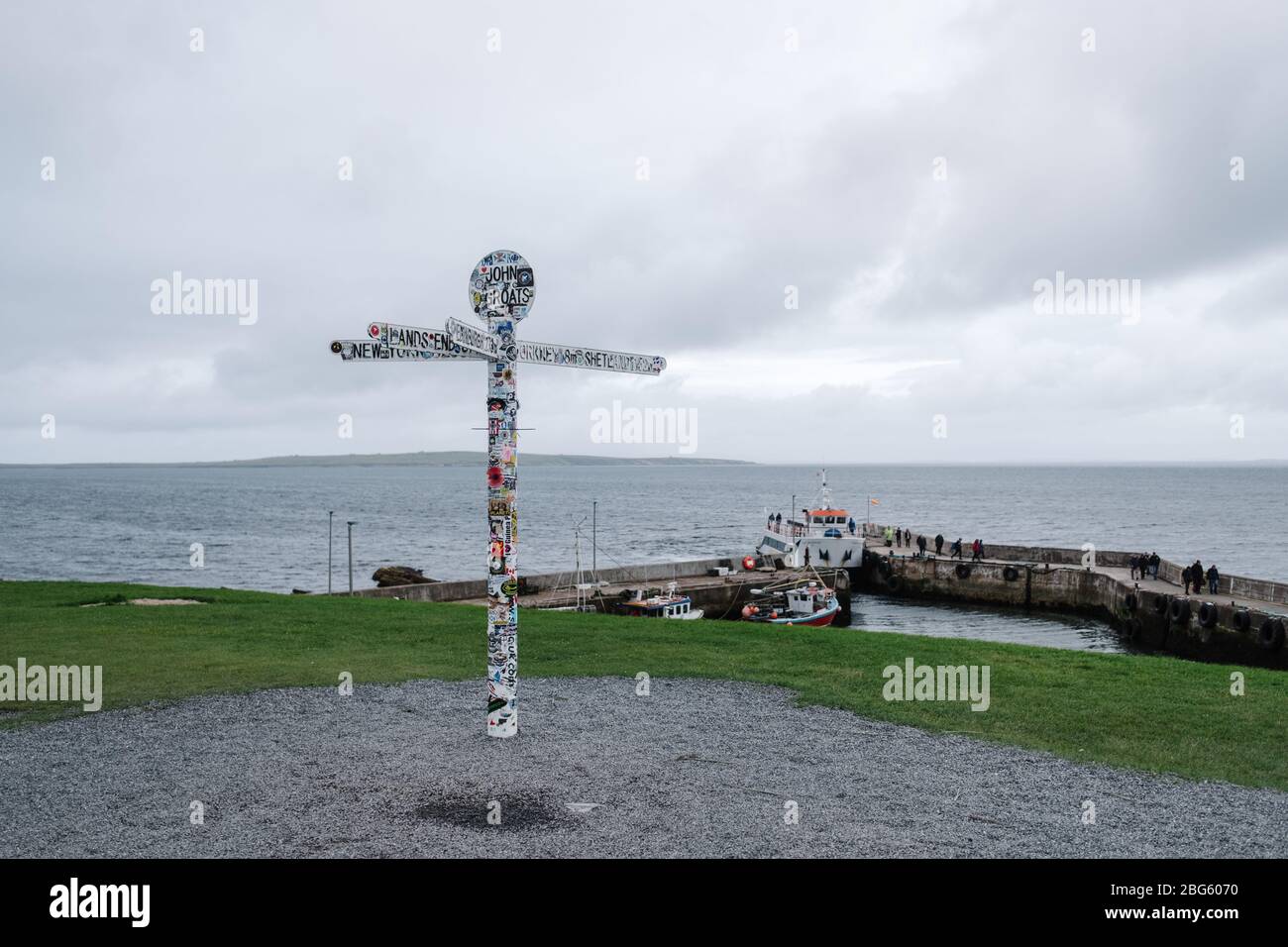 Famous landmark and signpost by the small harbour in John O' Groats, Caithness, Scotland, UK. Stock Photo