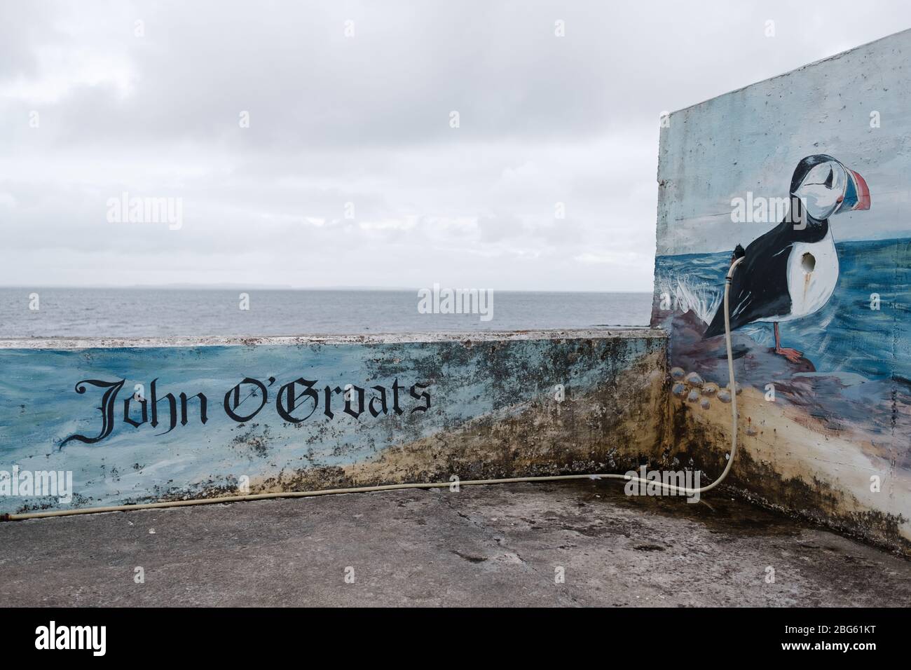 Mural depicting a Puffin with the words 'John O' Groats' on the harbour wall looking out to sea from John O' Groats harbour in the north of Scotland. Stock Photo