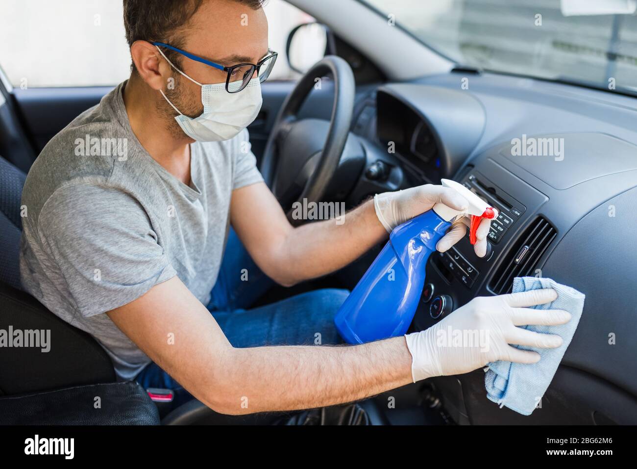 Driver With Face Surgical Mask Using Disinfectant And Microfiber Cloth 