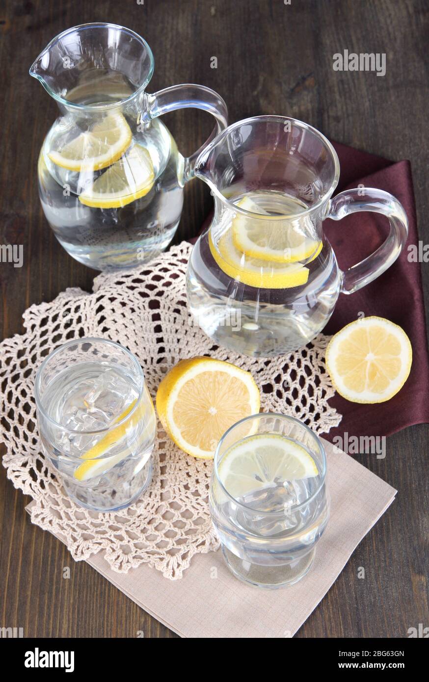 Glass pitchers of water and glasses on wooden table close-up Stock ...