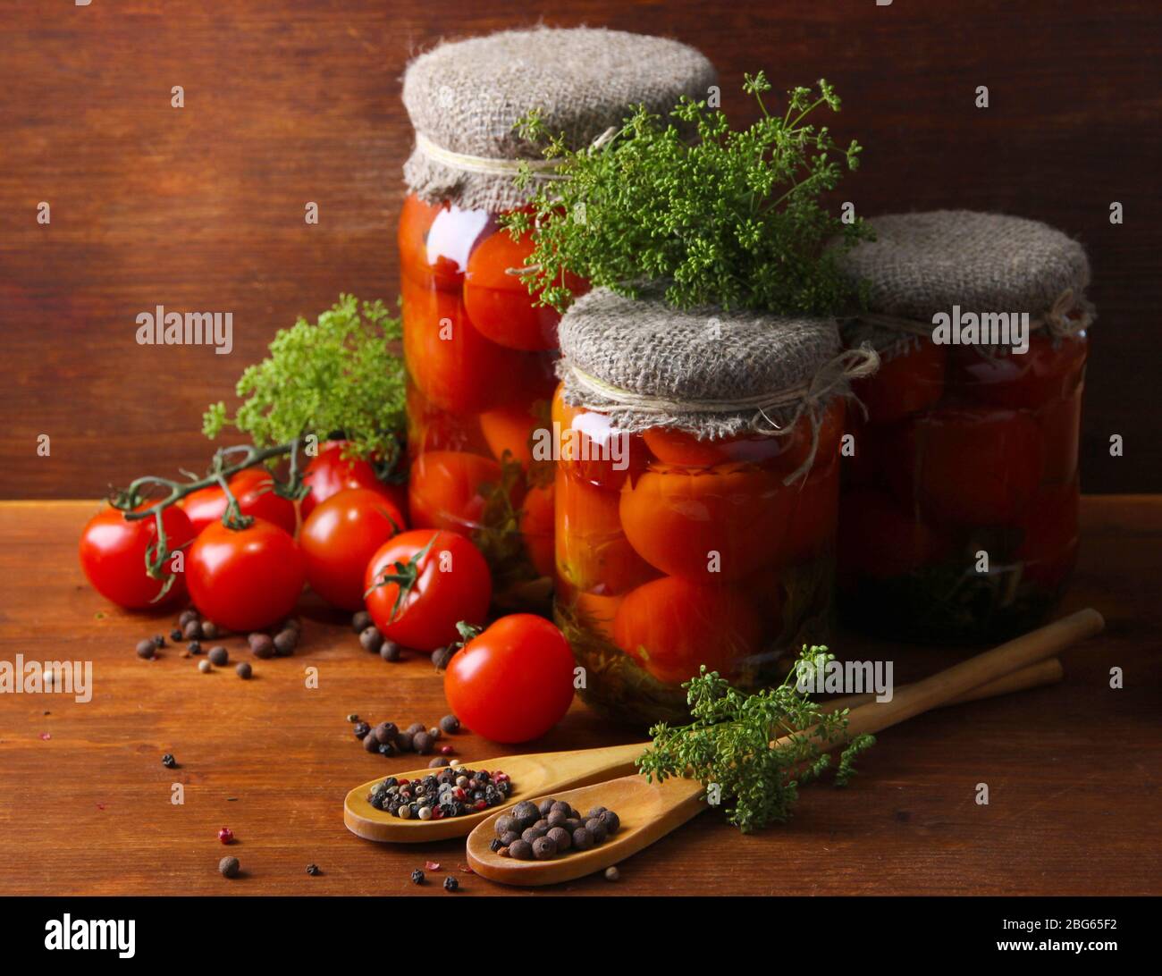 Tasty canned and fresh tomatoes on wooden table Stock Photo - Alamy