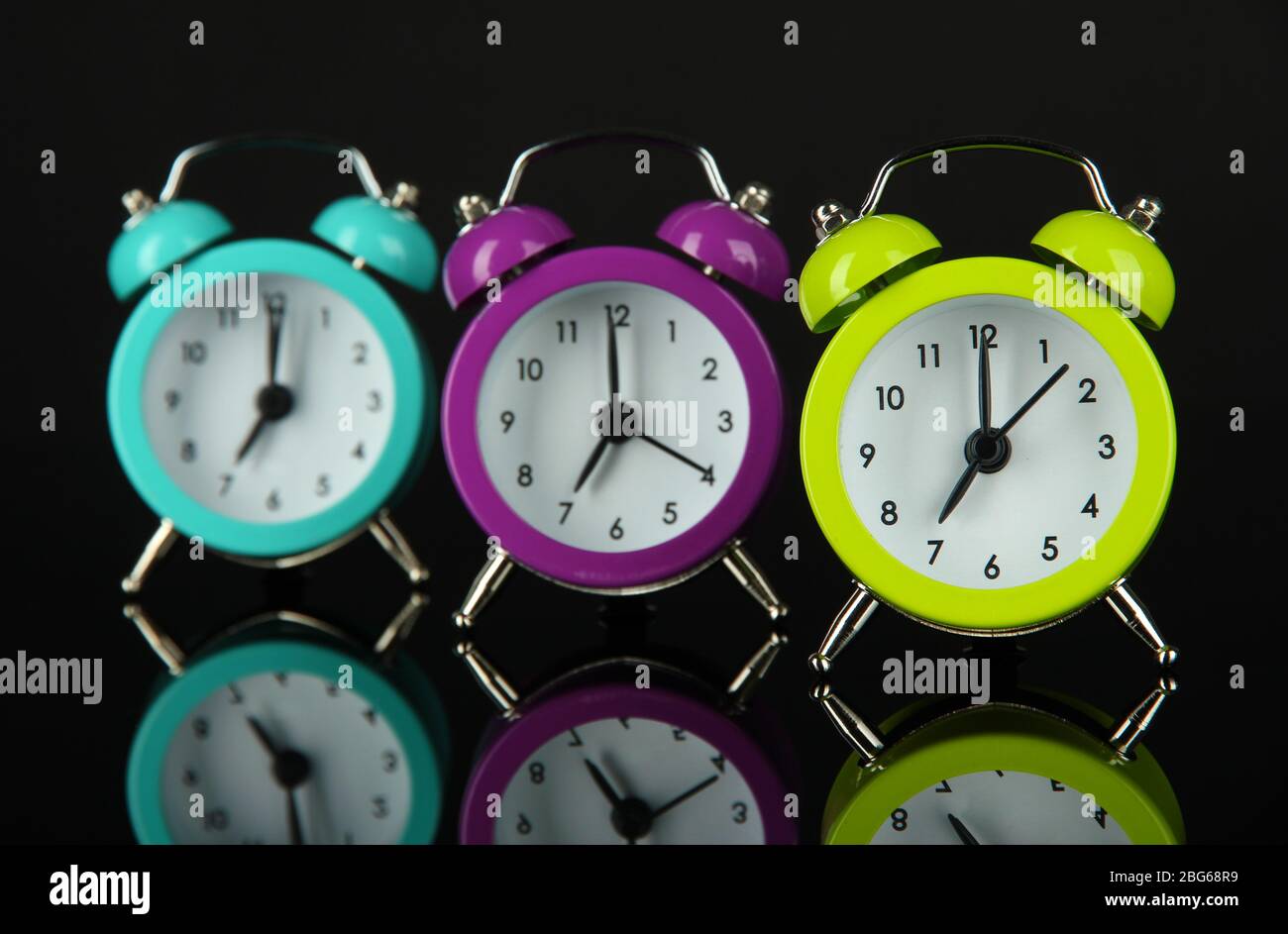Colorful alarm clock on dark grey background Stock Photo - Alamy