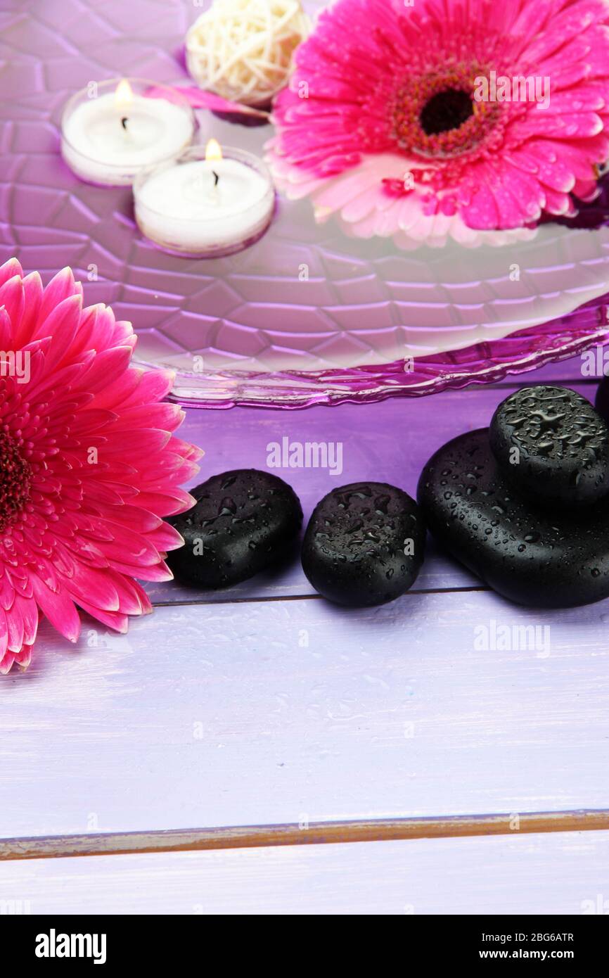 Spa stones, beautiful gerbera flowers and candles on water Stock Photo ...