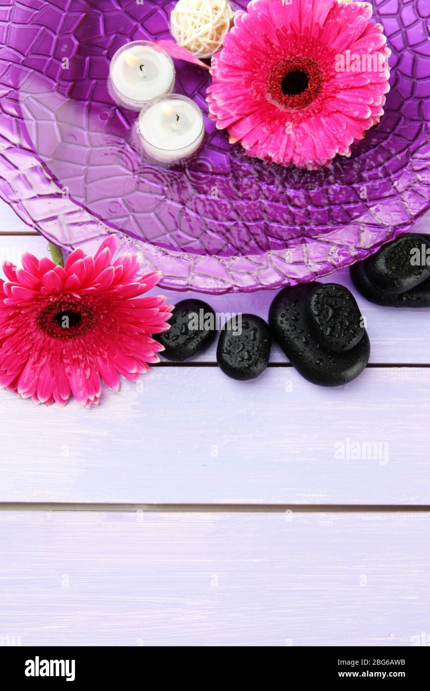 Spa stones, beautiful gerbera flowers and candles on water Stock Photo ...
