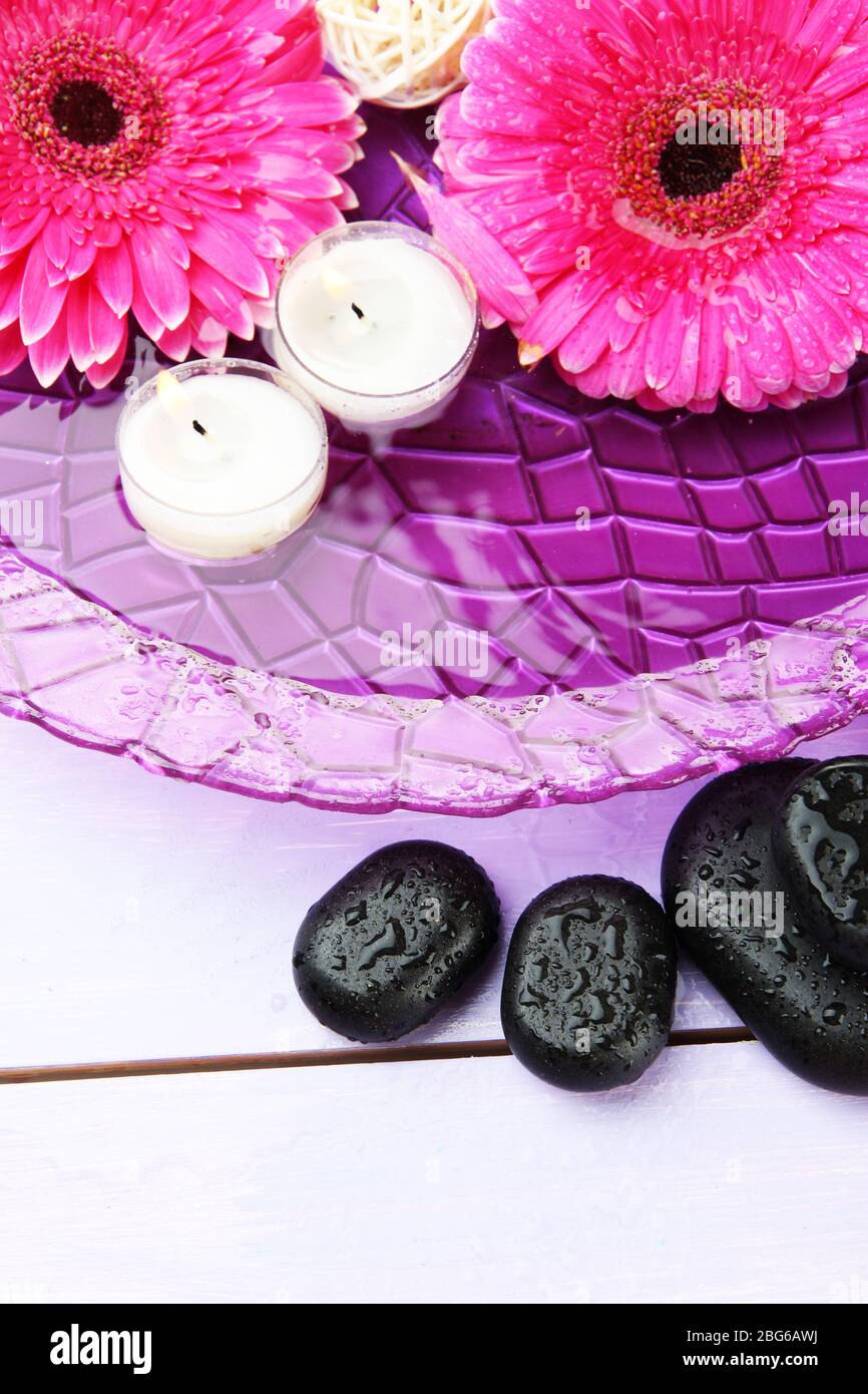 Spa stones, beautiful gerbera flowers and candles on water Stock Photo ...