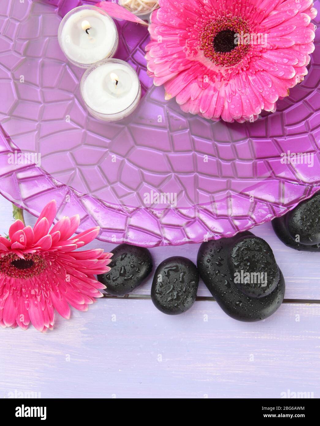 Spa stones, beautiful gerbera flowers and candles on water Stock Photo ...