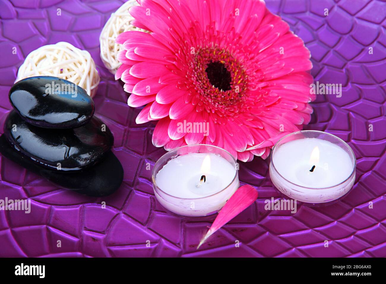 Spa stones, beautiful gerbera and candles on water Stock Photo - Alamy