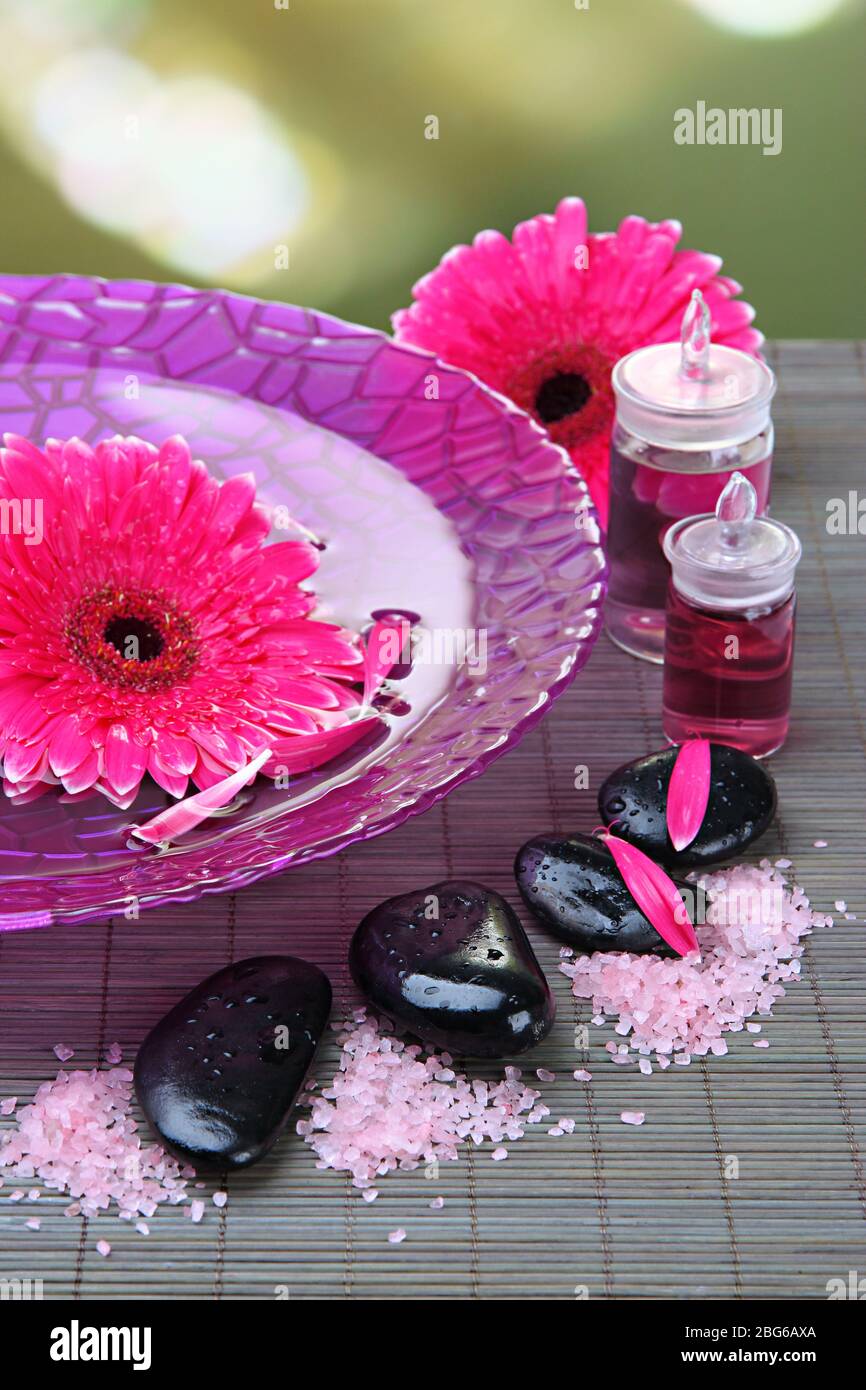 Gerbera flowers on water and spa stones on bamboo mat Stock Photo - Alamy