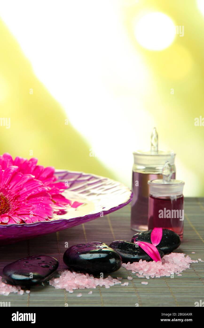 Gerbera flowers on water and spa stones on bamboo mat Stock Photo - Alamy