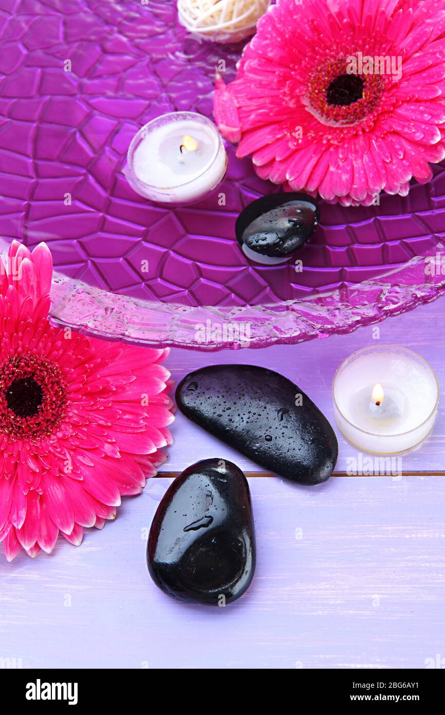 Spa stones, beautiful gerbera flowers and candles on water Stock Photo ...