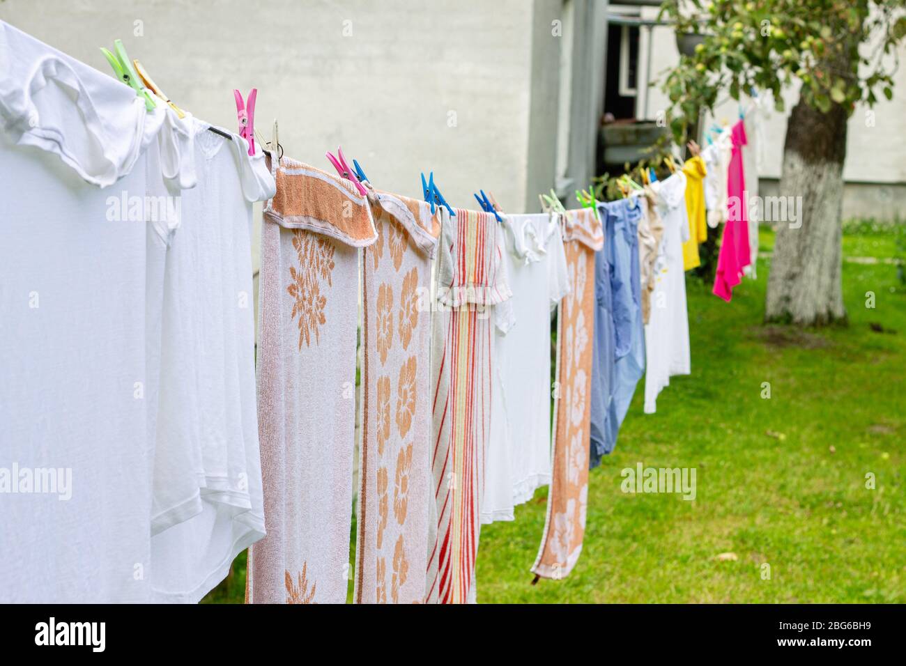 Colorful laundry hanging on rope in summer garden in typical