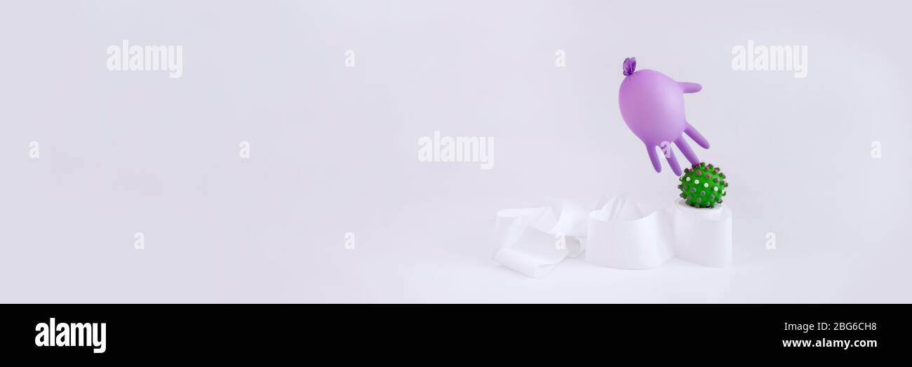 Toilet paper, virus and purple protective medical glove inflated like balloon on gray background. Surreal banner of flu coronavirus Covid-19 and quara Stock Photo