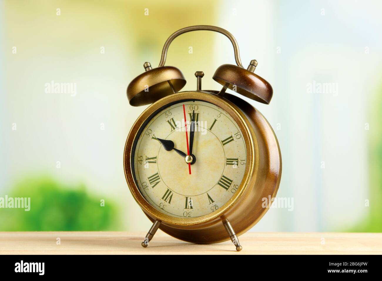 Old alarm clock on bright background Stock Photo - Alamy