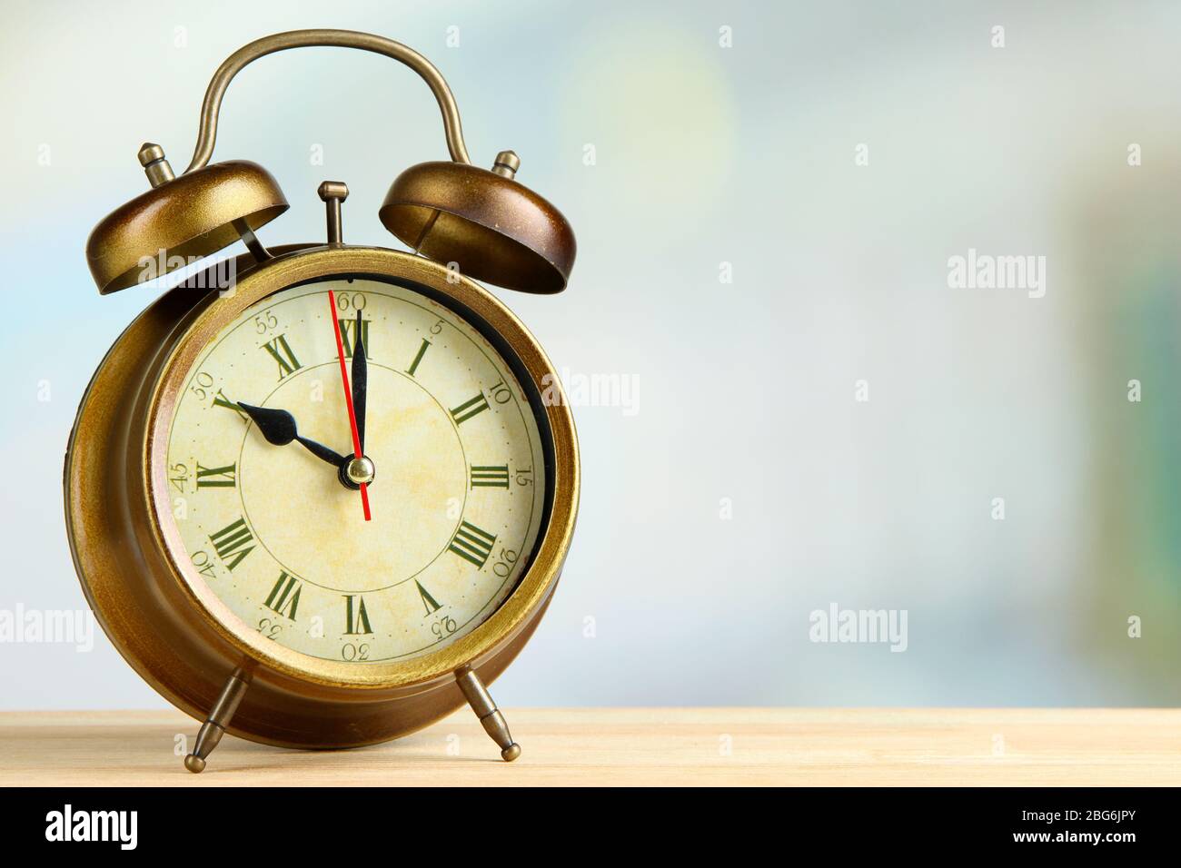 Old alarm clock on bright background Stock Photo - Alamy